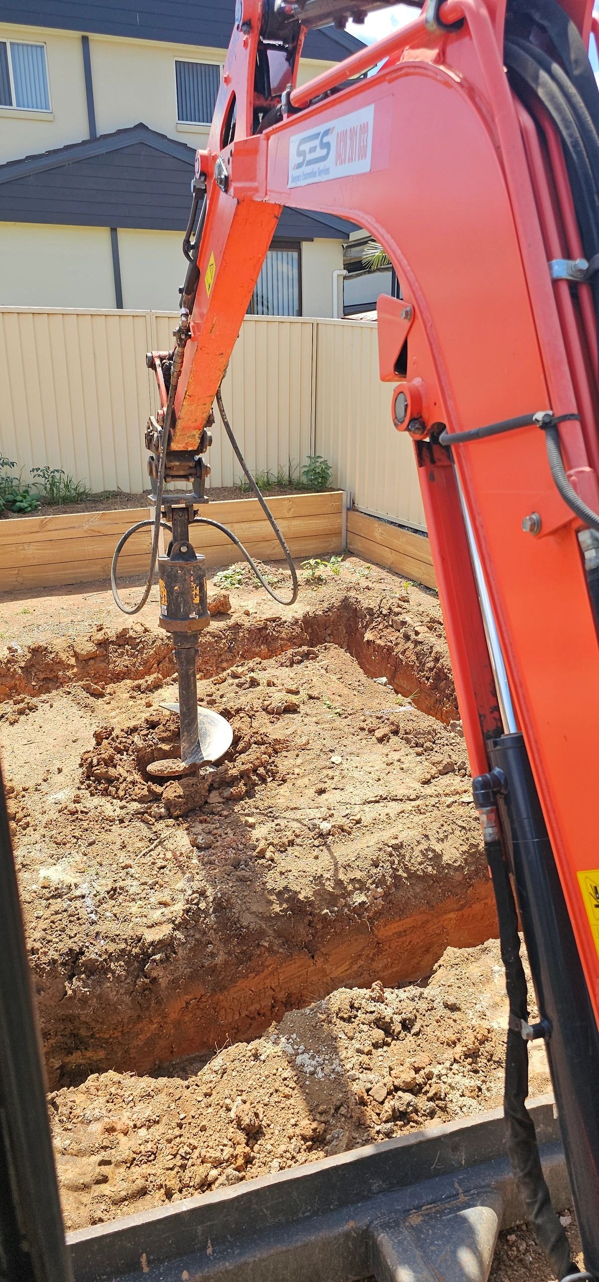 Pile driver operating in excavated trench